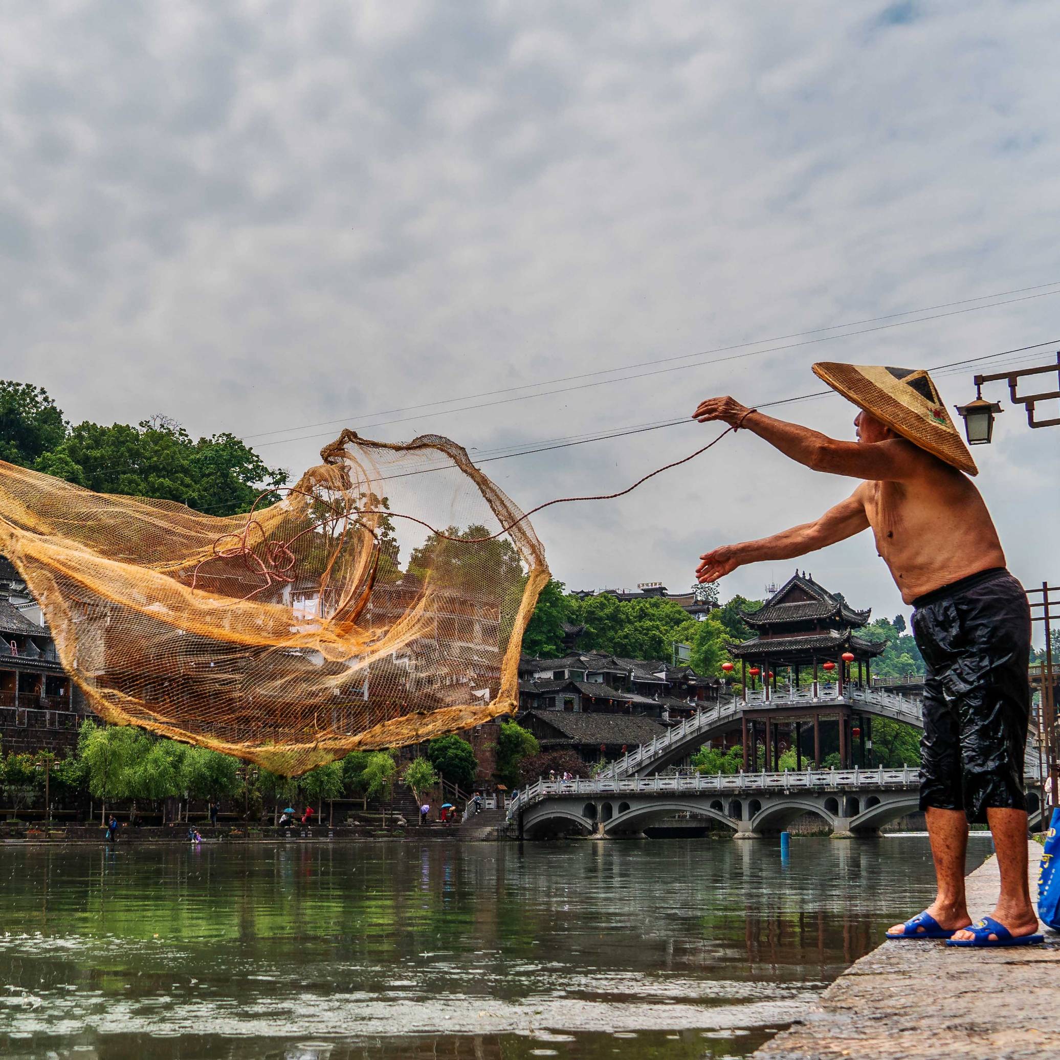 A Fishermen throwing his nets at Tuojiang River