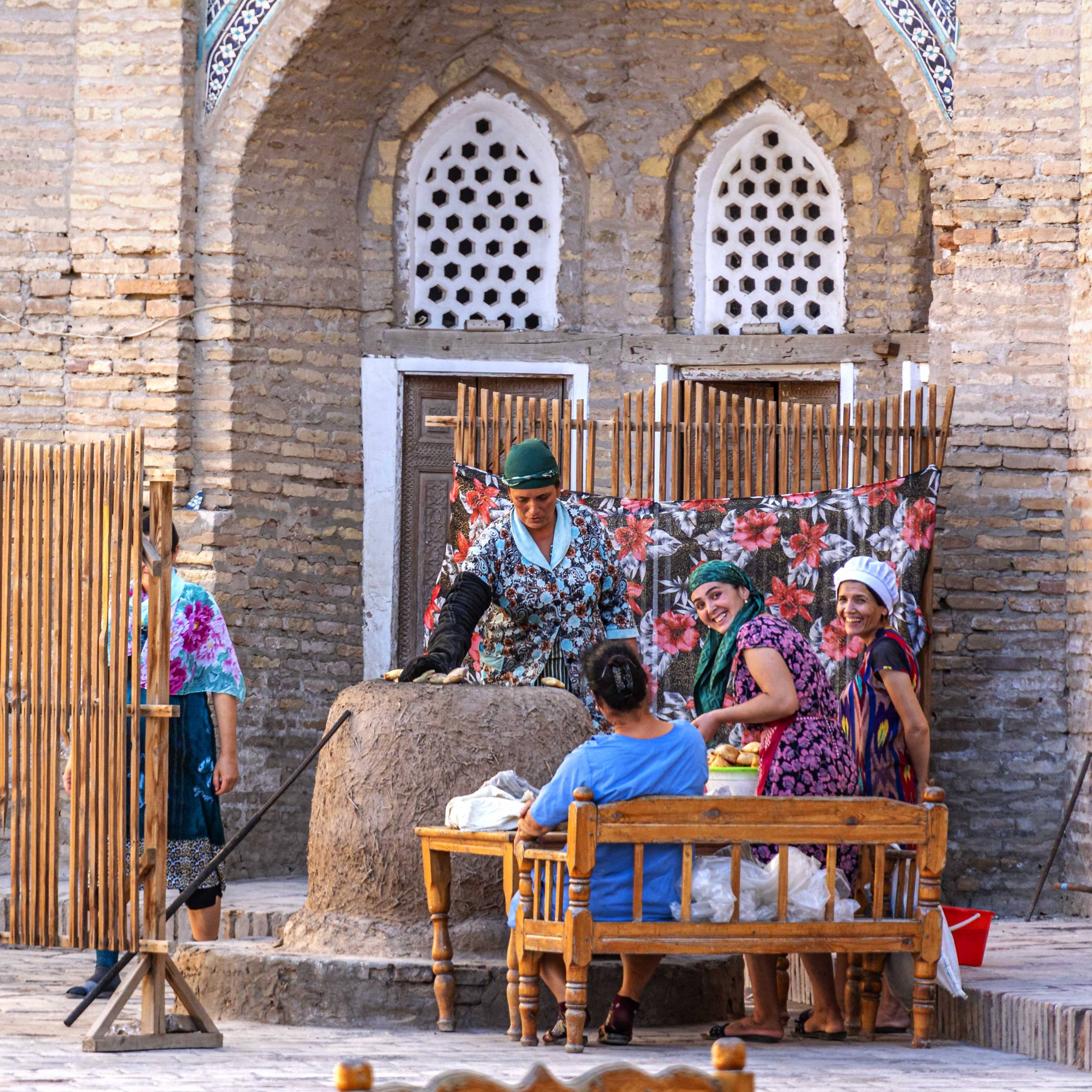 Women baking bread in a traditional clay oven